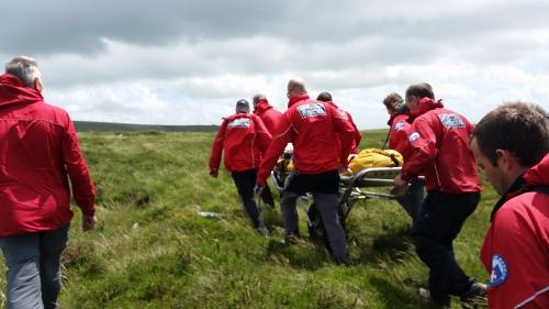Dartmoor Rescue transporting a casualty on a stretcher to the ambulance
